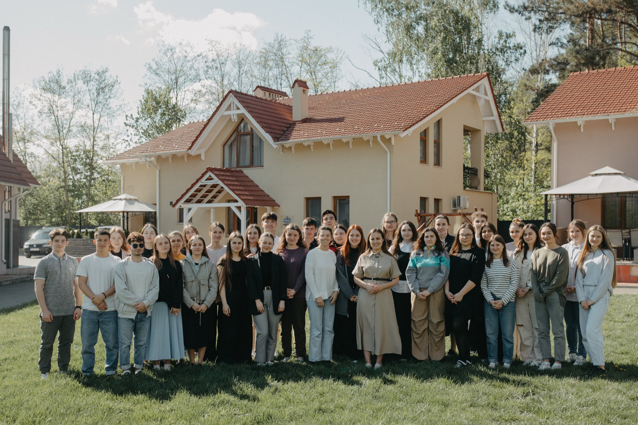 The Vatra Village family — children, young adults, and house parents outside a home in Moldova