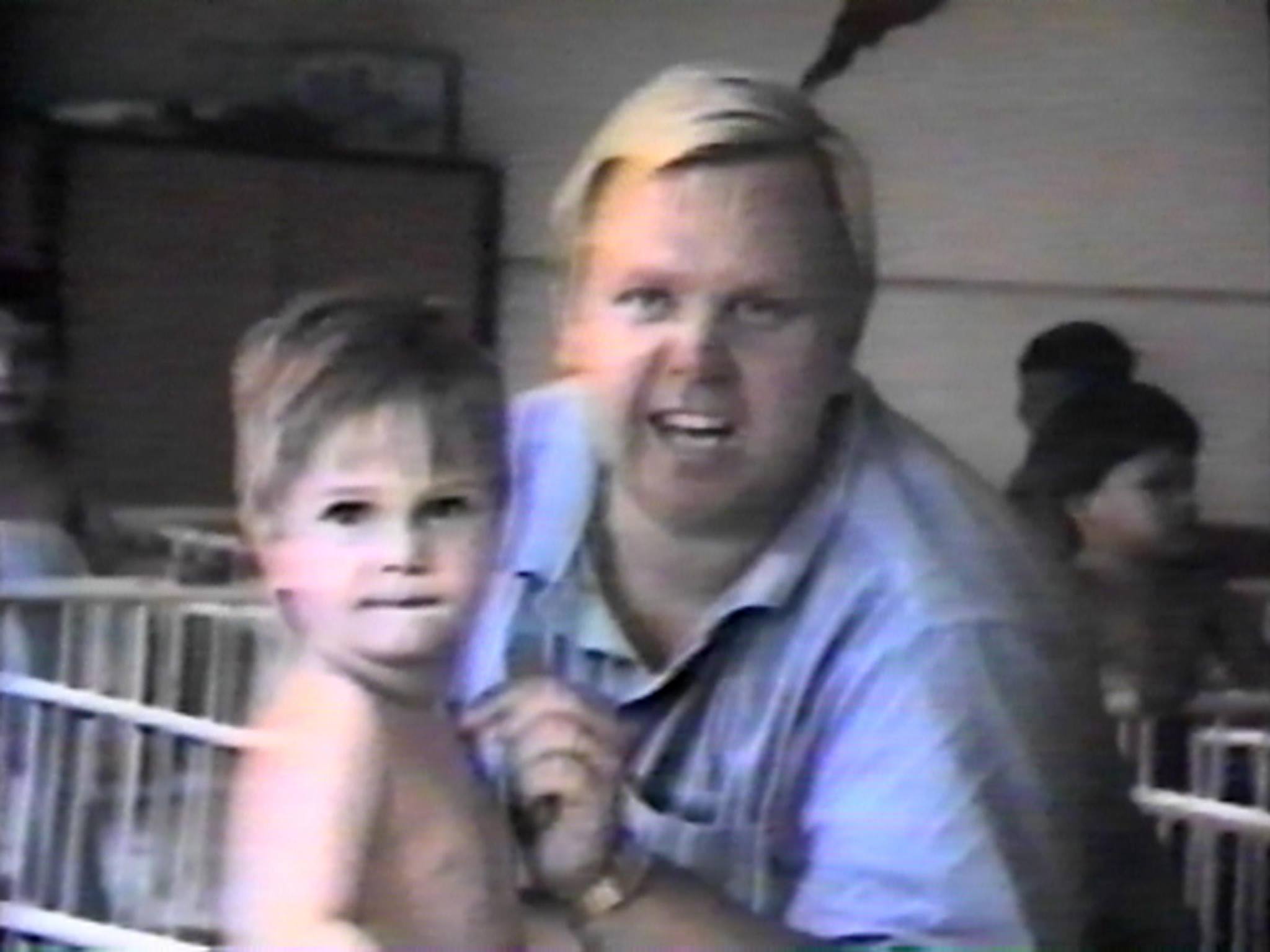 Philip Cameron holding baby Andrew in a Romanian orphanage, 1990